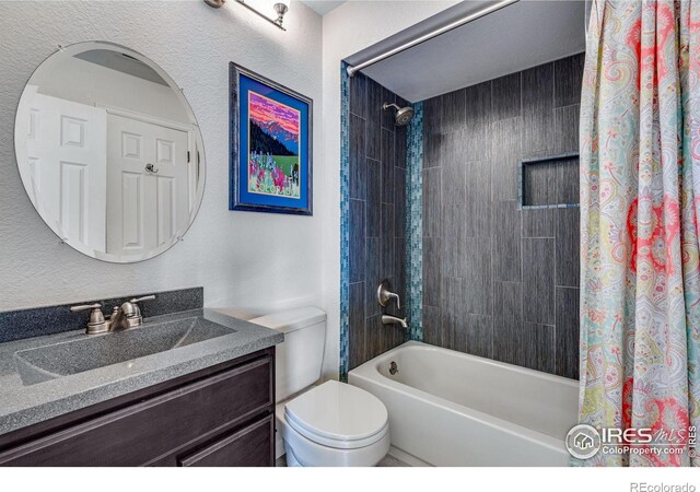 bathroom featuring shower / bath combo, a textured wall, vanity, and toilet