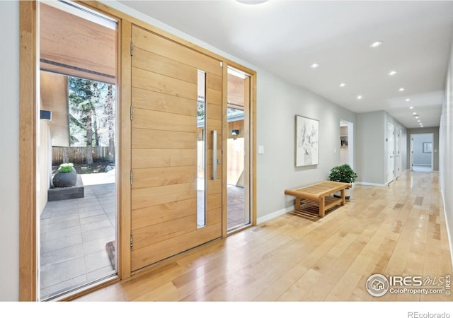 foyer featuring light wood-style floors, recessed lighting, and baseboards