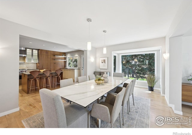 dining area featuring light wood-type flooring and baseboards