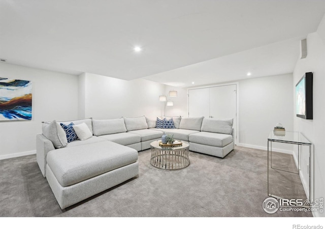 carpeted living area with recessed lighting and baseboards