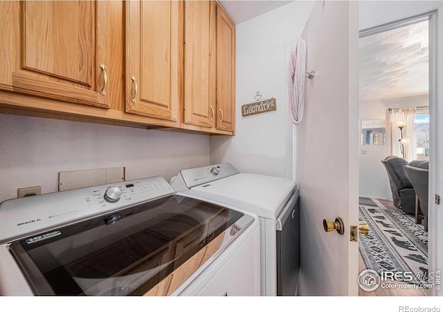 laundry room featuring independent washer and dryer and cabinet space