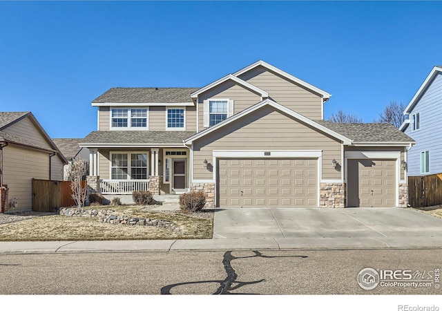 view of front of house with covered porch, a garage, fence, concrete driveway, and stone siding