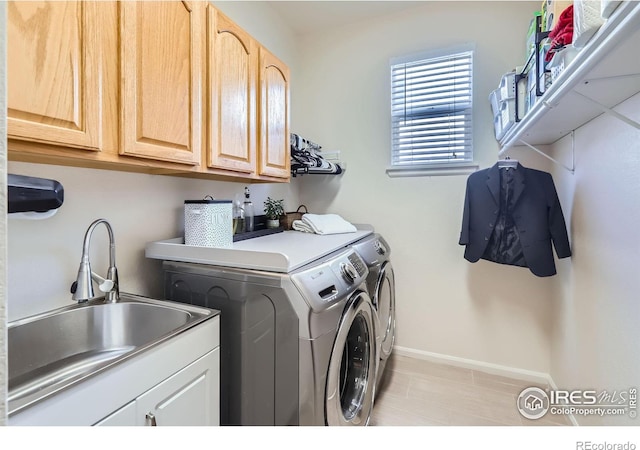 laundry room featuring washing machine and dryer, baseboards, and cabinet space