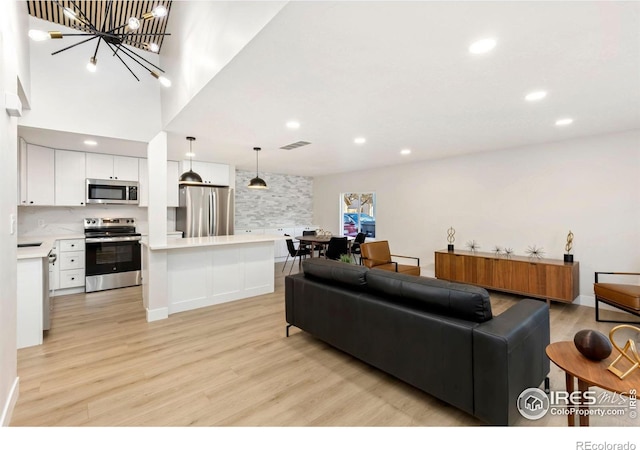 living room with recessed lighting, visible vents, and light wood finished floors