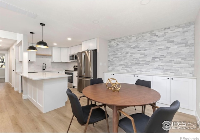 dining area with recessed lighting and light wood finished floors