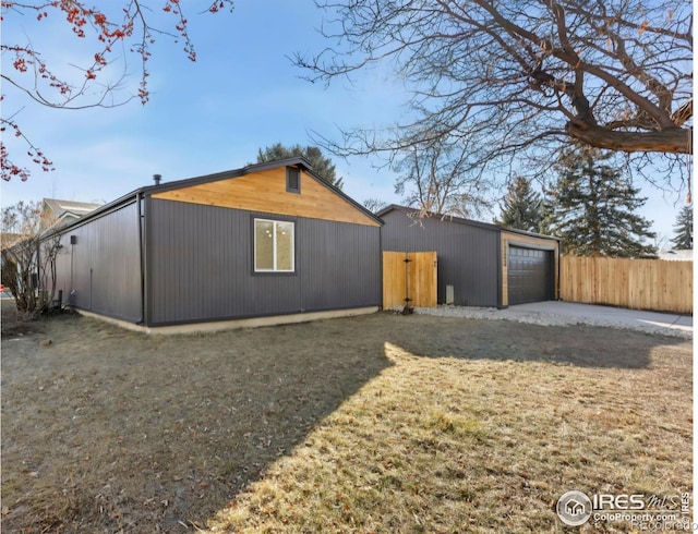 view of property exterior with an outbuilding, fence, and a garage