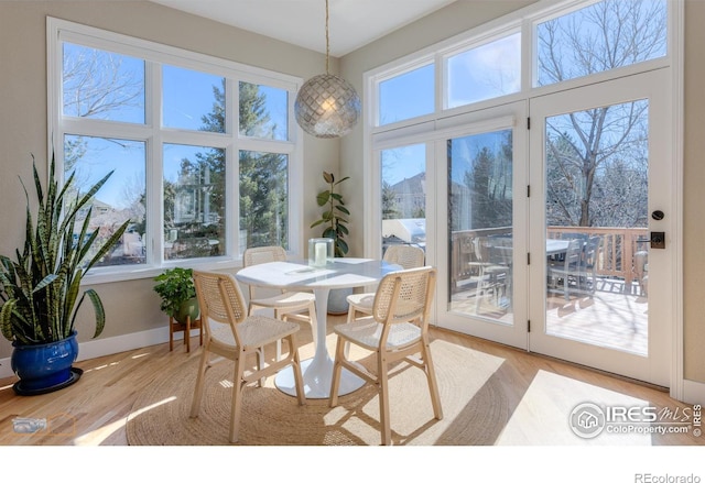 dining area featuring light wood-style flooring and baseboards