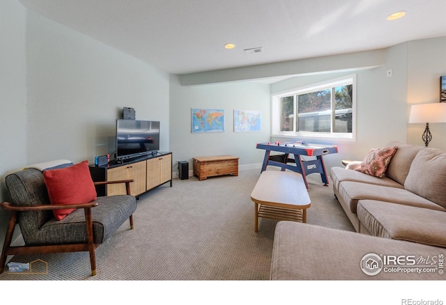 living area with recessed lighting, visible vents, and light colored carpet