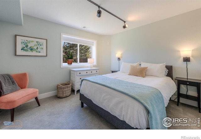 bedroom with rail lighting, baseboards, visible vents, and carpet flooring