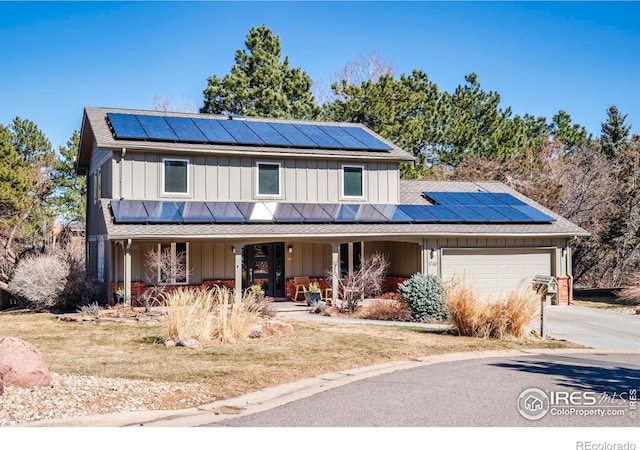 view of front facade featuring solar panels, concrete driveway, an attached garage, covered porch, and board and batten siding