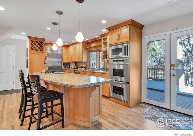 kitchen with built in appliances, french doors, a sink, and a wealth of natural light