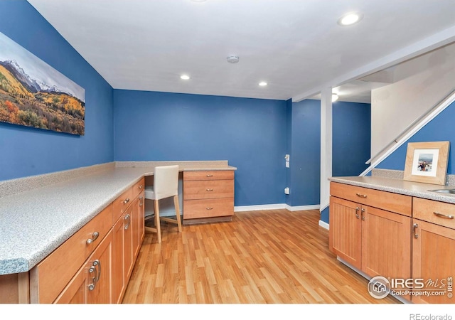 unfurnished office featuring baseboards, light wood-type flooring, and recessed lighting