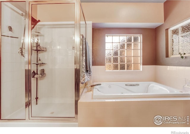 bathroom featuring a stall shower and a garden tub