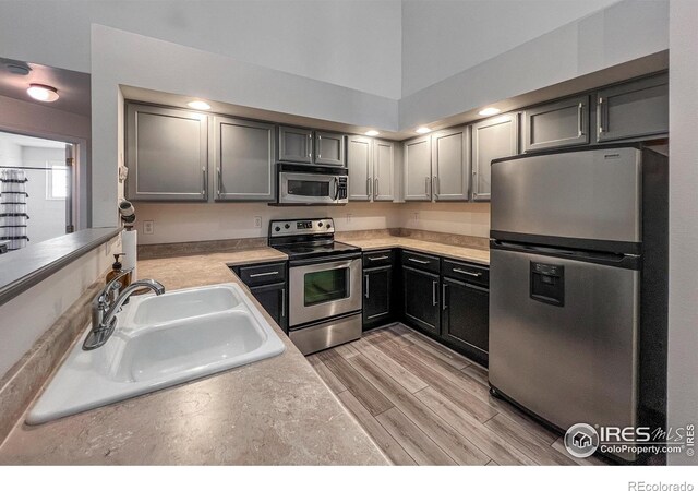 1004 Lucca Dr, Evans, CO 80620 - kitchen with light countertops, a sink, wood finish floors, and stainless steel appliances
