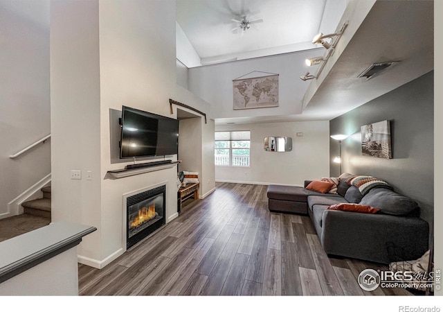 1004 Lucca Dr, Evans, CO 80620 - living area with a glass covered fireplace, visible vents, stairway, wood finished floors, and baseboards