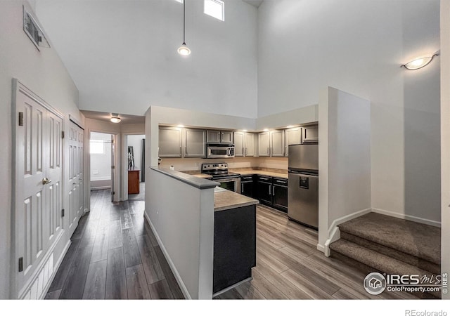 1004 Lucca Dr, Evans, CO 80620 - kitchen featuring visible vents, light countertops, a peninsula, wood finished floors, and stainless steel appliances