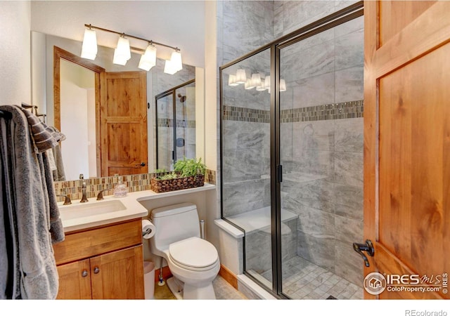 full bath with vanity, a stall shower, and toilet