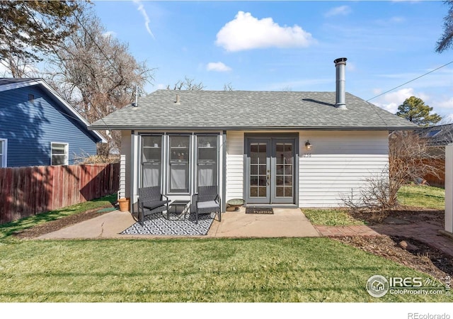 back of house featuring a shingled roof, french doors, fence, and a lawn