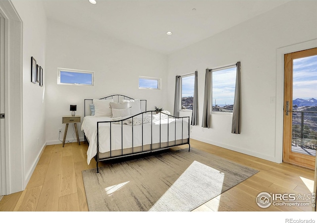 bedroom with light wood-type flooring, access to outside, baseboards, and recessed lighting