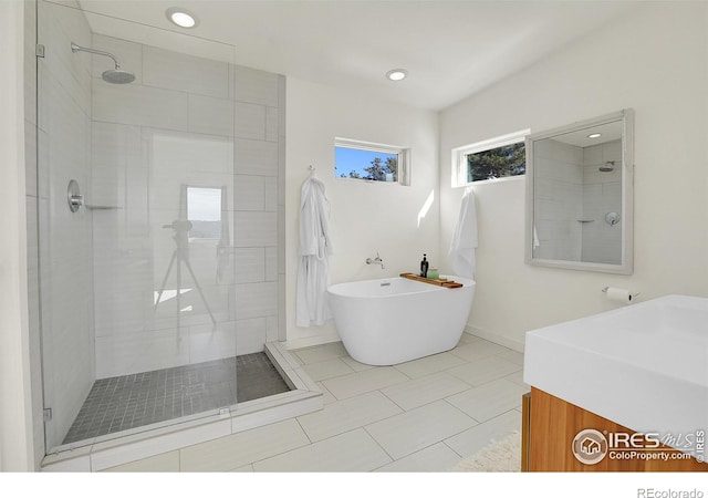 full bathroom with a stall shower, a freestanding tub, and recessed lighting