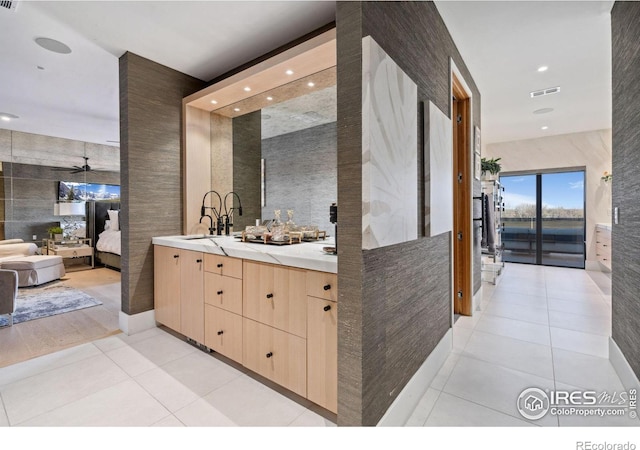 ensuite bathroom with ensuite bathroom, ceiling fan, vanity, visible vents, and tile patterned floors