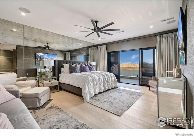 bedroom with access to outside, wood finished floors, and visible vents