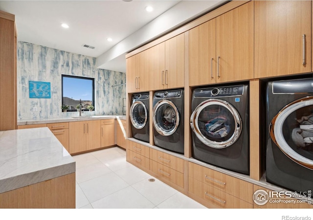 laundry room featuring washer and clothes dryer, recessed lighting, cabinet space, a sink, and wallpapered walls