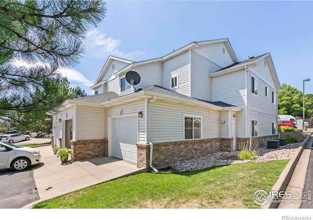 view of front of property featuring central AC unit, concrete driveway, an attached garage, a front lawn, and brick siding