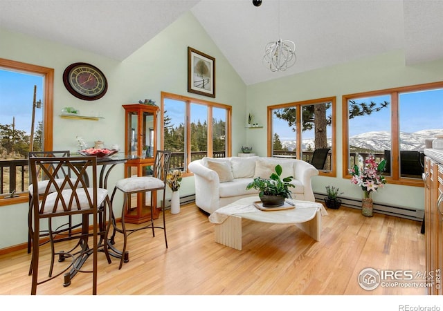 living room with a baseboard heating unit, high vaulted ceiling, wood finished floors, and a chandelier