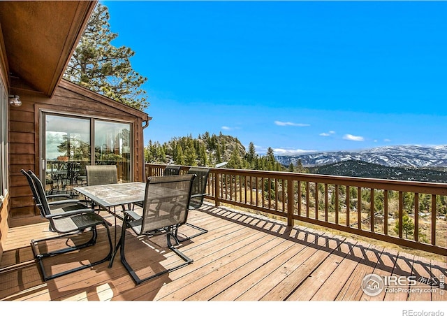 deck featuring outdoor dining space and a mountain view