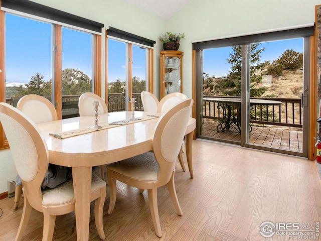 dining room with lofted ceiling and light wood finished floors