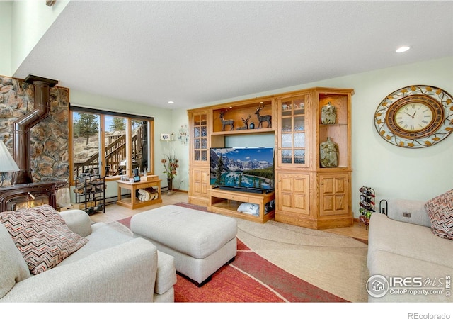 living area with a wood stove, a textured ceiling, and recessed lighting