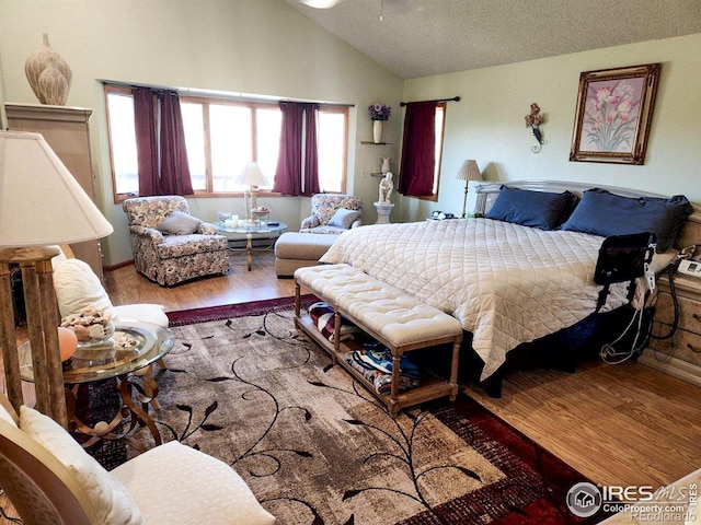 bedroom featuring a textured ceiling, high vaulted ceiling, and wood finished floors