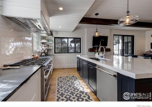 kitchen featuring stainless steel appliances, beamed ceiling, plenty of natural light, and a sink