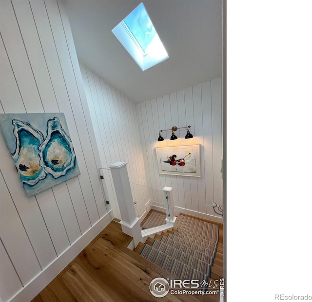 mudroom featuring a skylight, baseboards, and wood finished floors