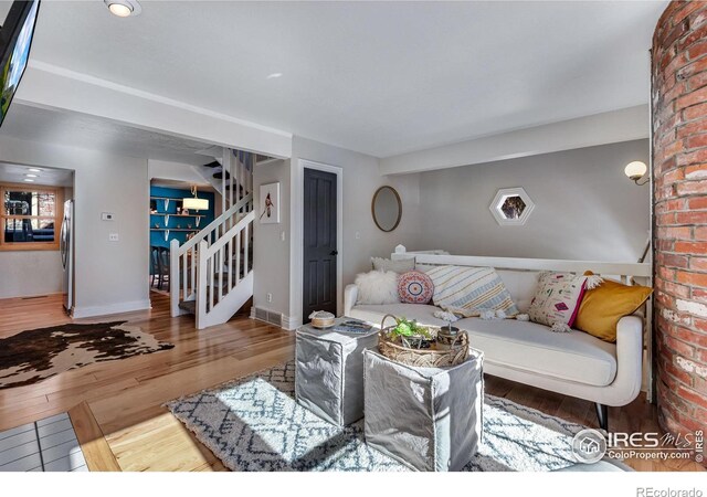 living room featuring stairway, baseboards, and wood finished floors