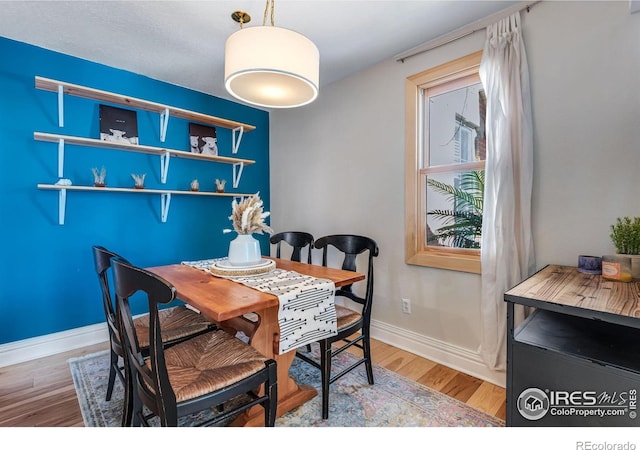 dining area with baseboards and wood finished floors