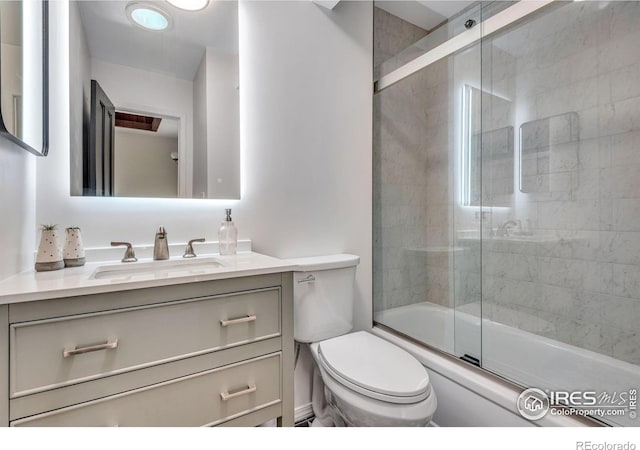 full bathroom with toilet, enclosed tub / shower combo, and vanity