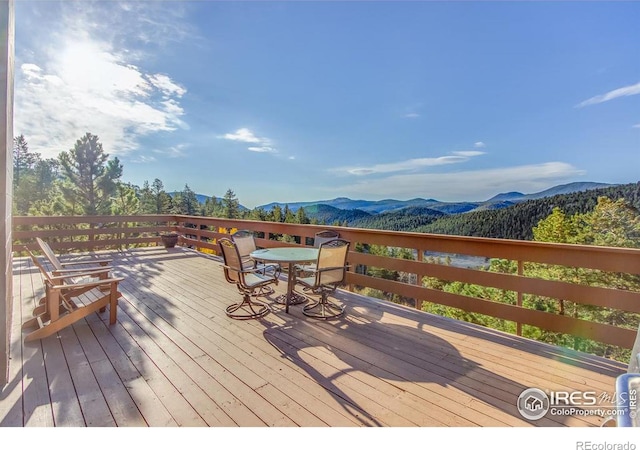 deck featuring outdoor dining area and a mountain view