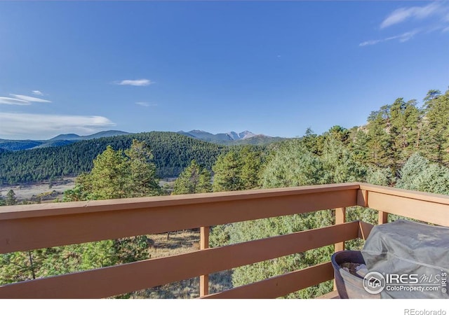 balcony featuring a mountain view and a view of trees