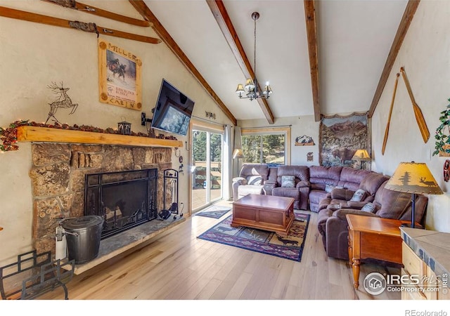 living room featuring beamed ceiling, wood finished floors, an inviting chandelier, a stone fireplace, and high vaulted ceiling