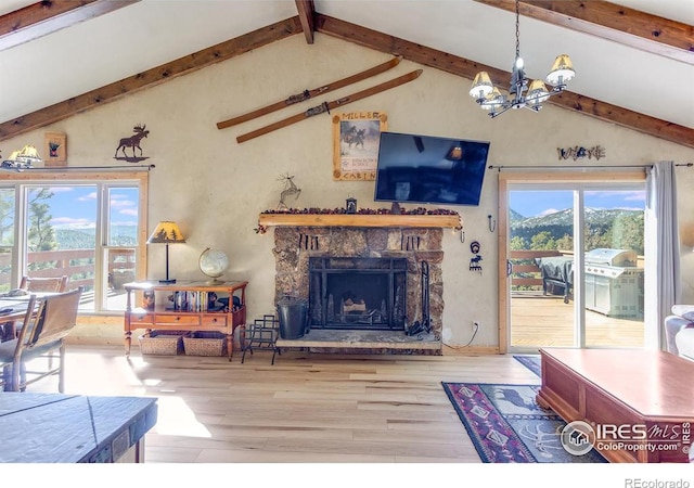 living area featuring beam ceiling, an inviting chandelier, a stone fireplace, wood finished floors, and high vaulted ceiling