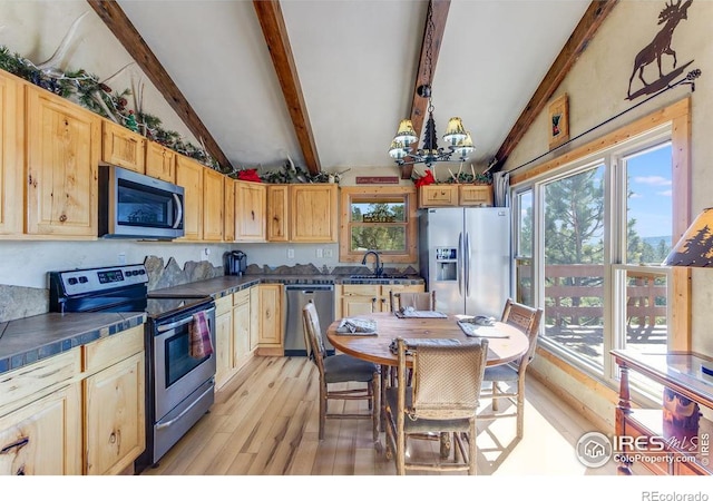 kitchen featuring lofted ceiling with beams, stainless steel appliances, light wood-type flooring, and an inviting chandelier