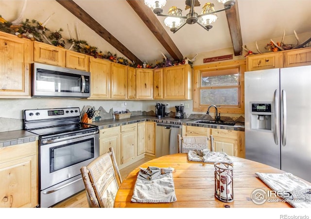 kitchen with vaulted ceiling with beams, tile countertops, stainless steel appliances, a sink, and a chandelier