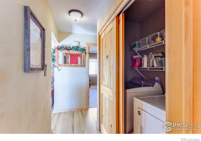 clothes washing area featuring laundry area, wood finished floors, and washing machine and dryer