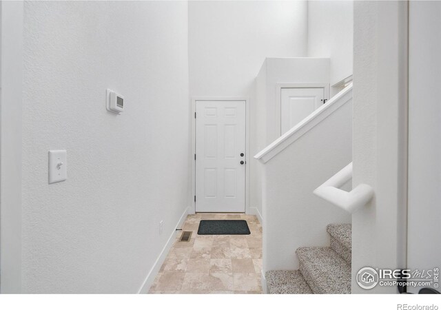 interior space featuring baseboards and stairway