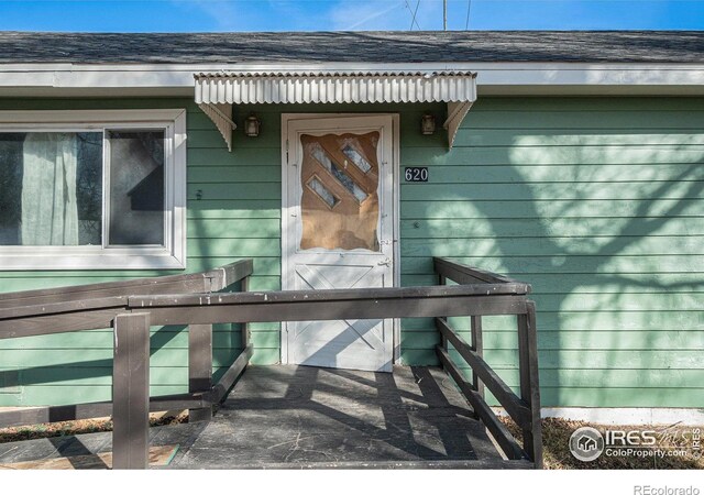 property entrance with a shingled roof