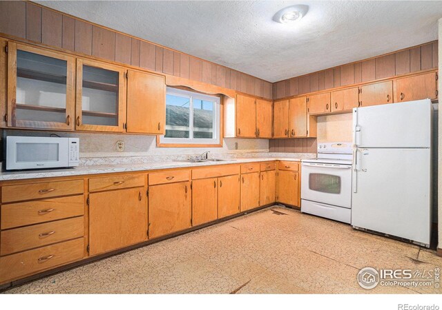 kitchen featuring a sink, white appliances, light countertops, and light floors