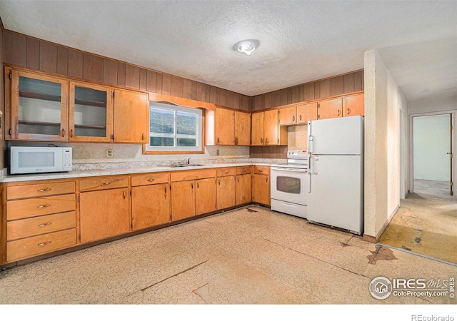 kitchen featuring white appliances, light countertops, a sink, and light floors