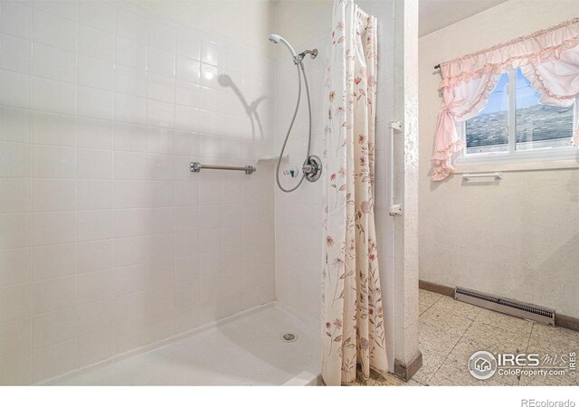 full bath with a baseboard heating unit, a stall shower, visible vents, and baseboards